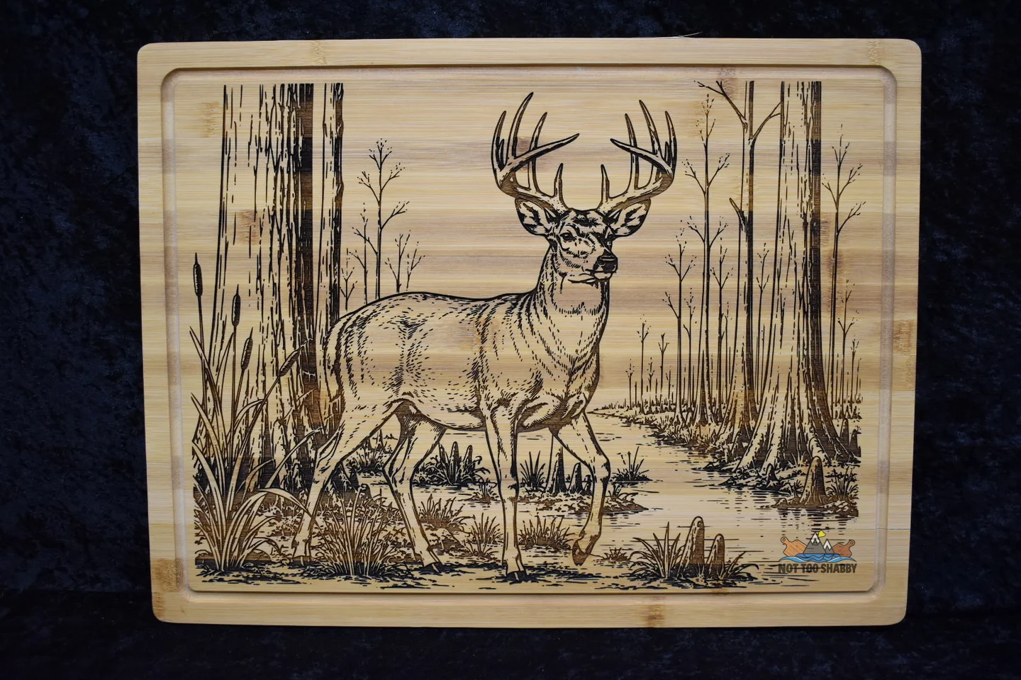 Detailed whitetail deer scene laser engraved on a bamboo cutting board